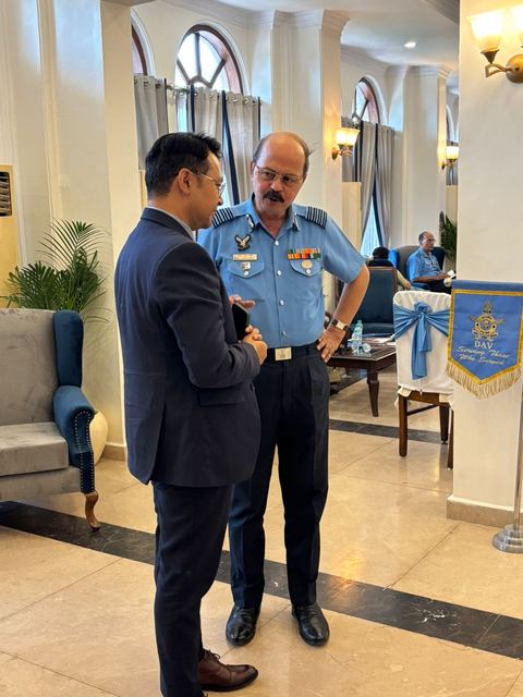 A team member in conversation with a senior officer beside a directorate pennant