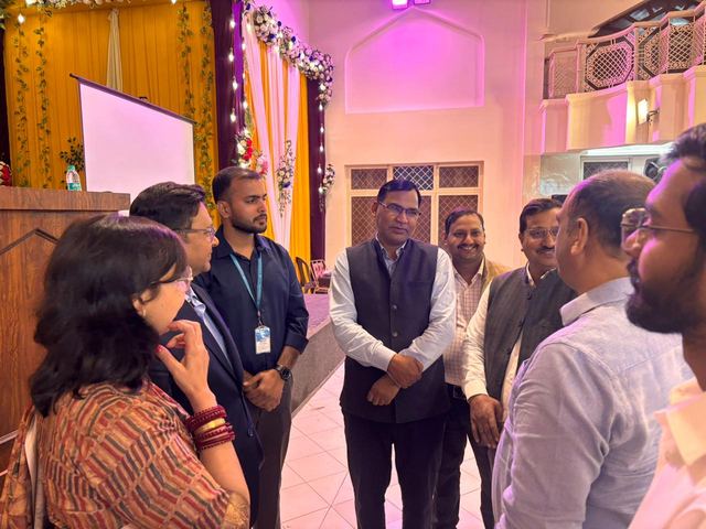 Organisers and team members in conversation beside a decorated stage before a session